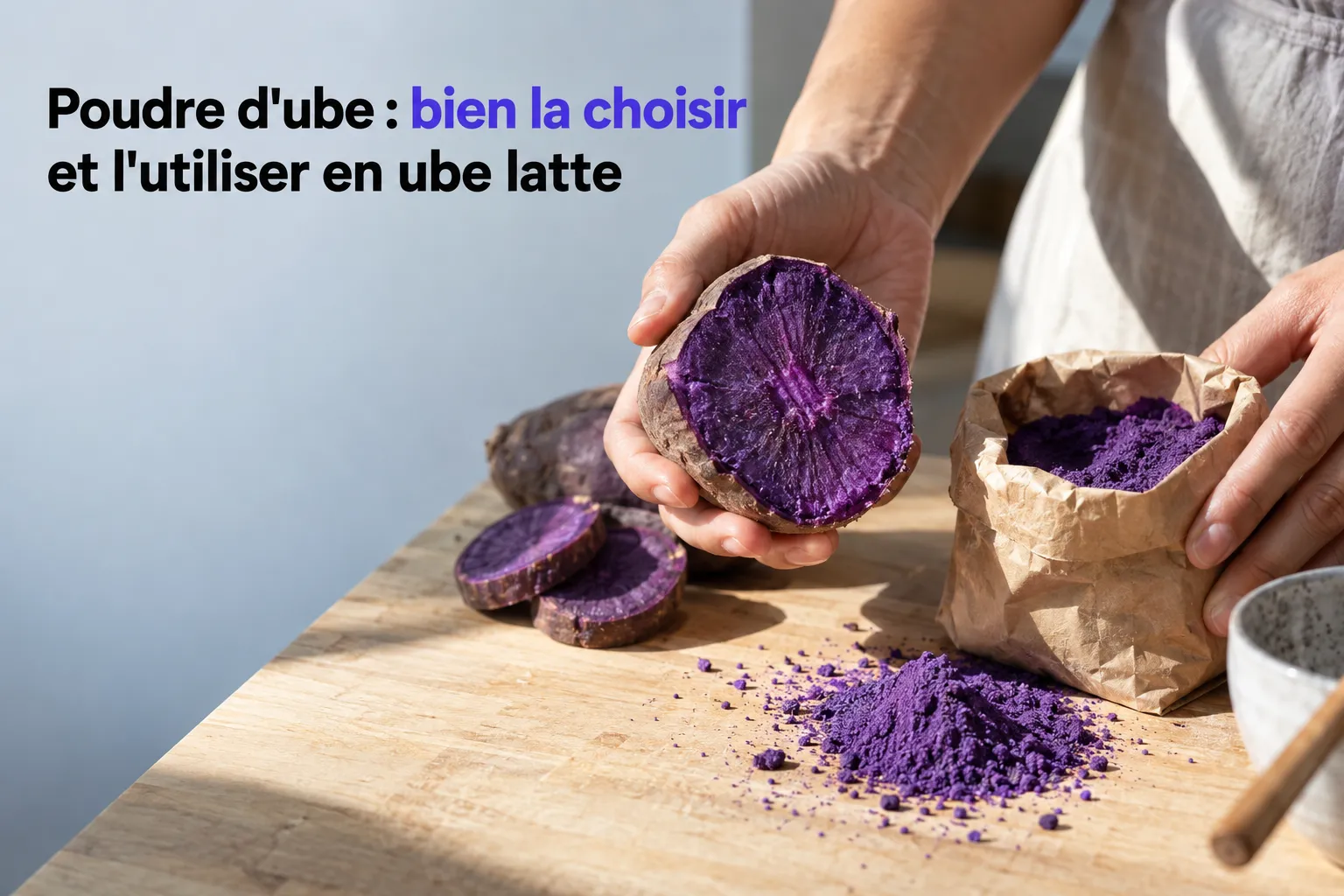 Purple ube powder and fine powder spread on a countertop, with a hand holding a slice of the plant and a bag