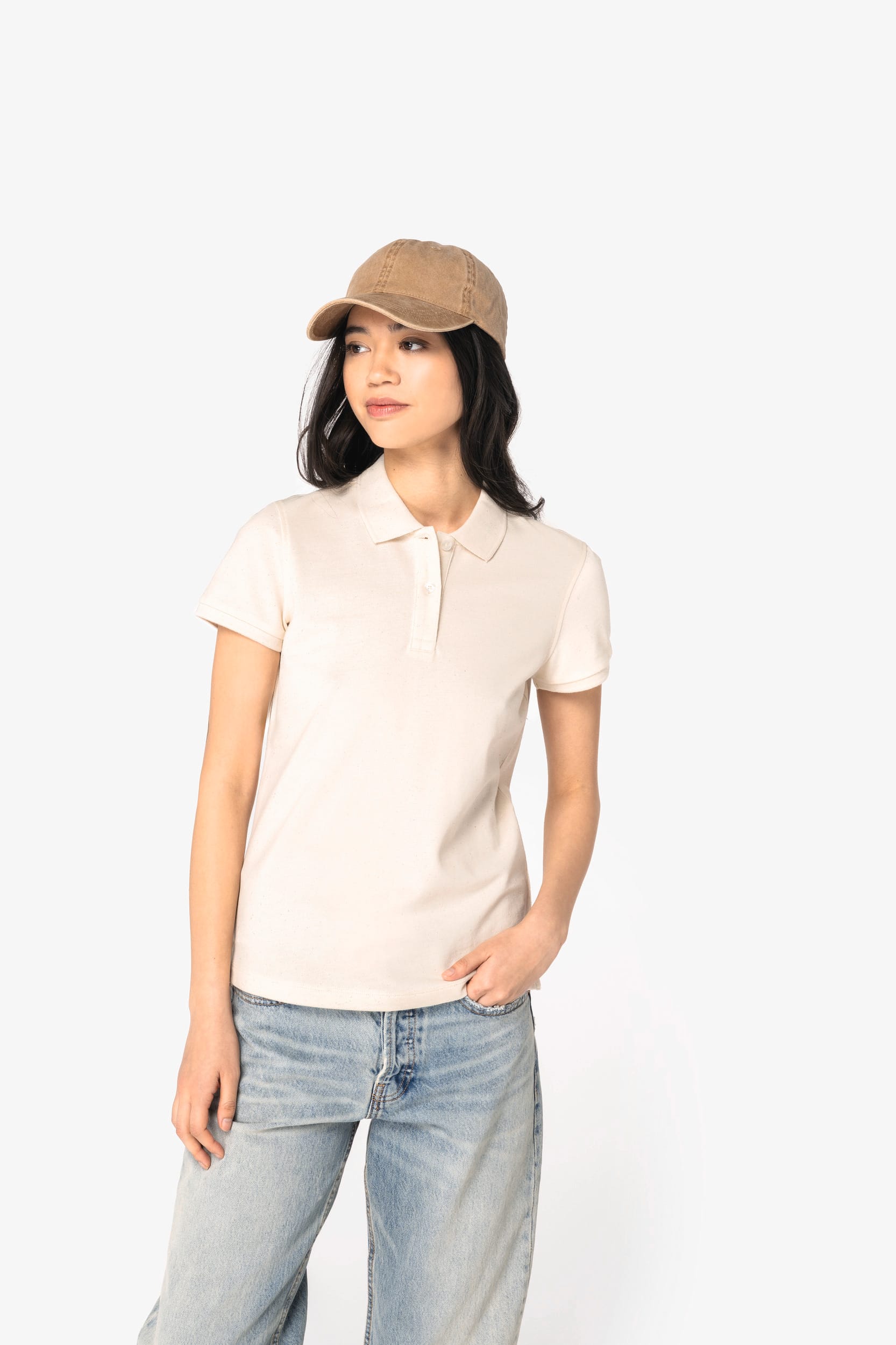 Polo personnalisé professionnel porté par une femme avec casquette beige, polo clair à col polo et jeans, style décontracté.