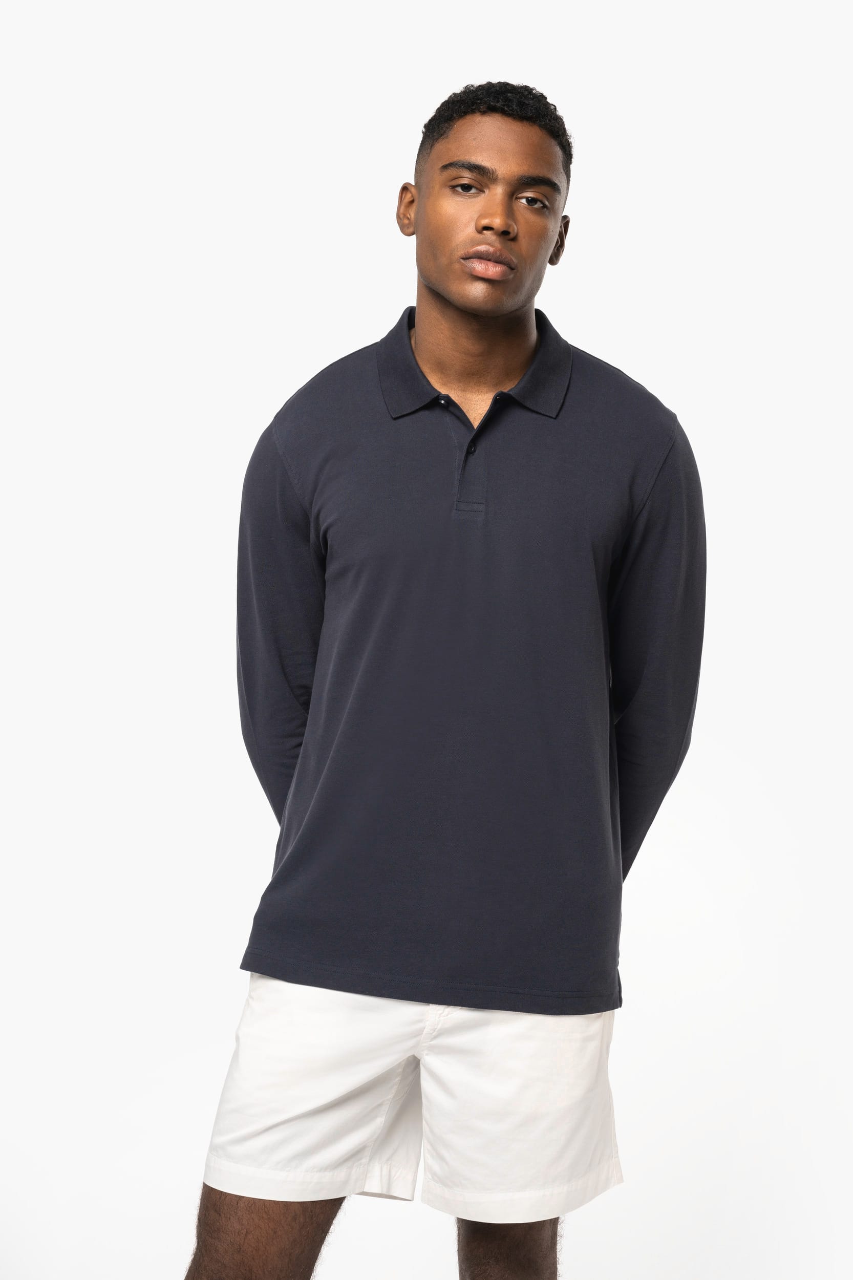 Polo personnalisé professionnel, polo à manches longues bleu marine porté par un homme, tenue décontractée avec short blanc.