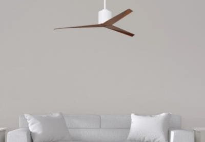 Ventilateur plafond ultra silencieux pour chambre design suspendu au plafond, au-dessus d’un canapé blanc dans un séjour minimaliste.