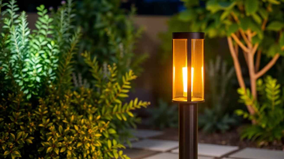 Lampadaire extérieur solaire allumé dans un jardin nocturne, entouré de buis et de plantes, ambiance chaleureuse.