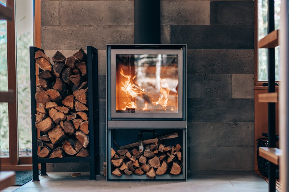 Une cheminée moderne avec bois de chauffage empilé, créant une ambiance chaleureuse et conviviale.