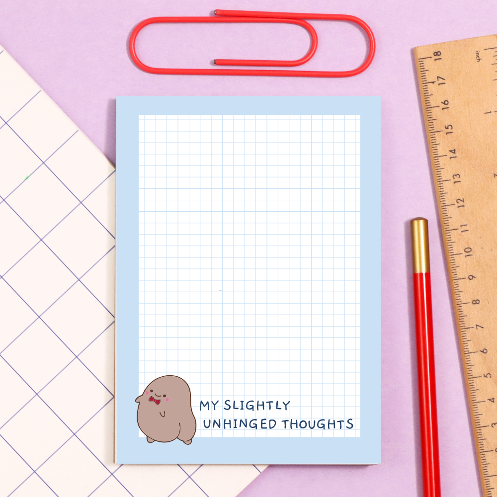 Soft blue stationery with a grid sheet and a cute brown blob character; caption reads “My slightly unhinged thoughts,” surrounded by a red paperclip, ruler, and pencil on a pastel background. Integrates how to manage adhd symptoms.