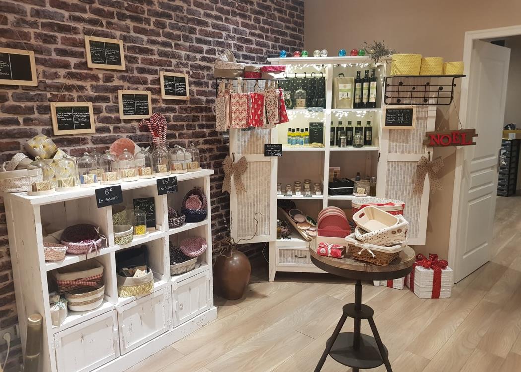 Étagères et caisse décoratives pleines de produits d’hygiène et de soins dans une boutique artisanale.