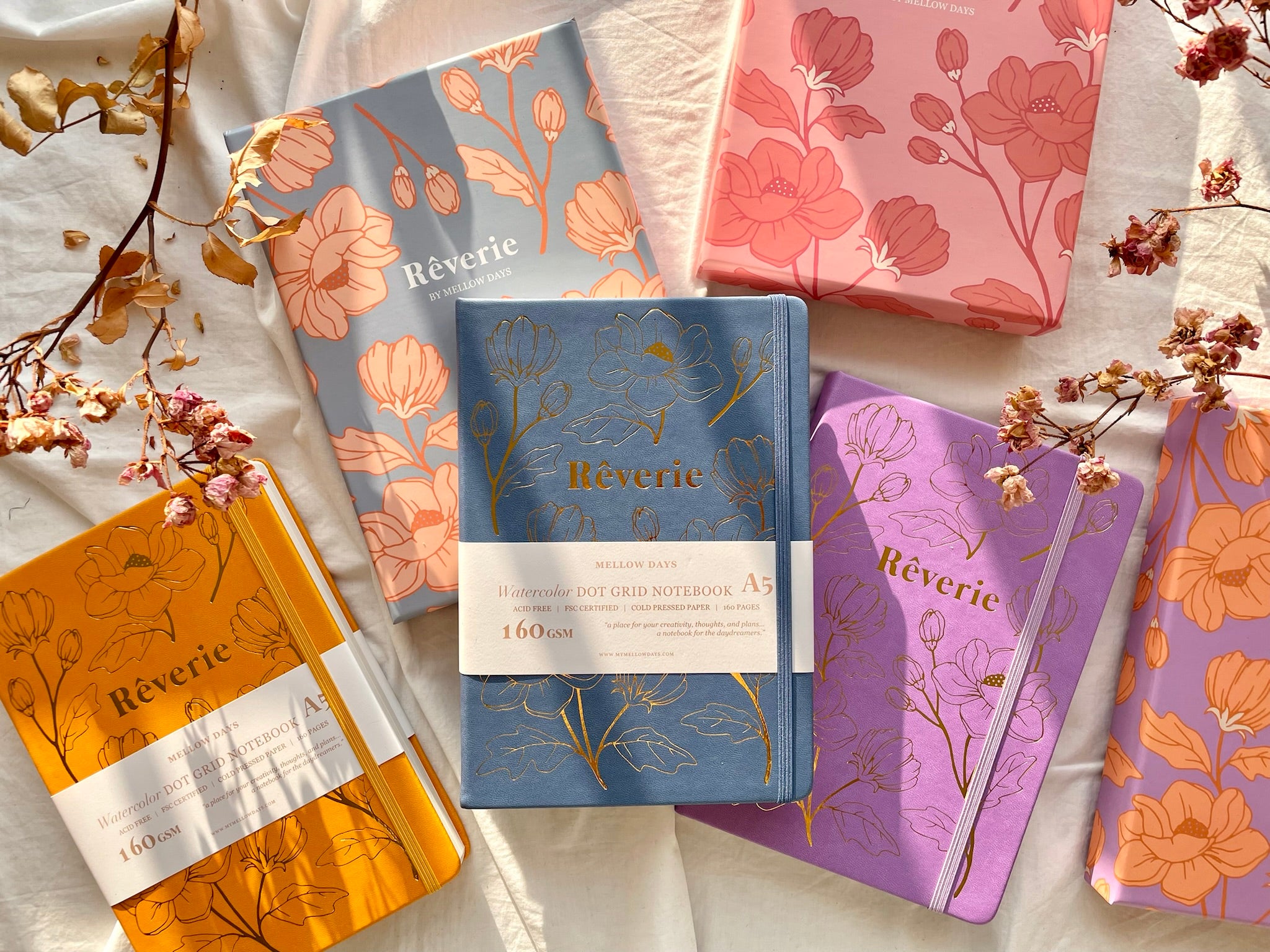 Colorful collection of elegantly designed Reverie watercolor dot grid notebooks in blue, orange, pink, purple with floral patterns. Colorful collection of elegantly designed Reverie watercolor dot grid notebooks in blue, orange, pink, purple with floral patterns.