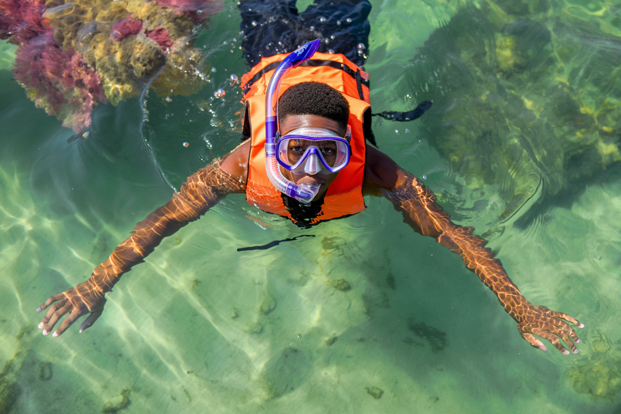 Persona che pratica snorkeling con maschera e boccaglio in superficie