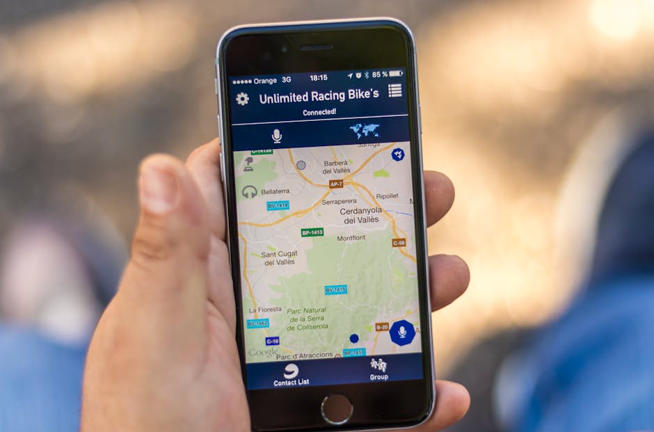 Main tenant un smartphone affichant une application de carte GPS avec des données de localisation.