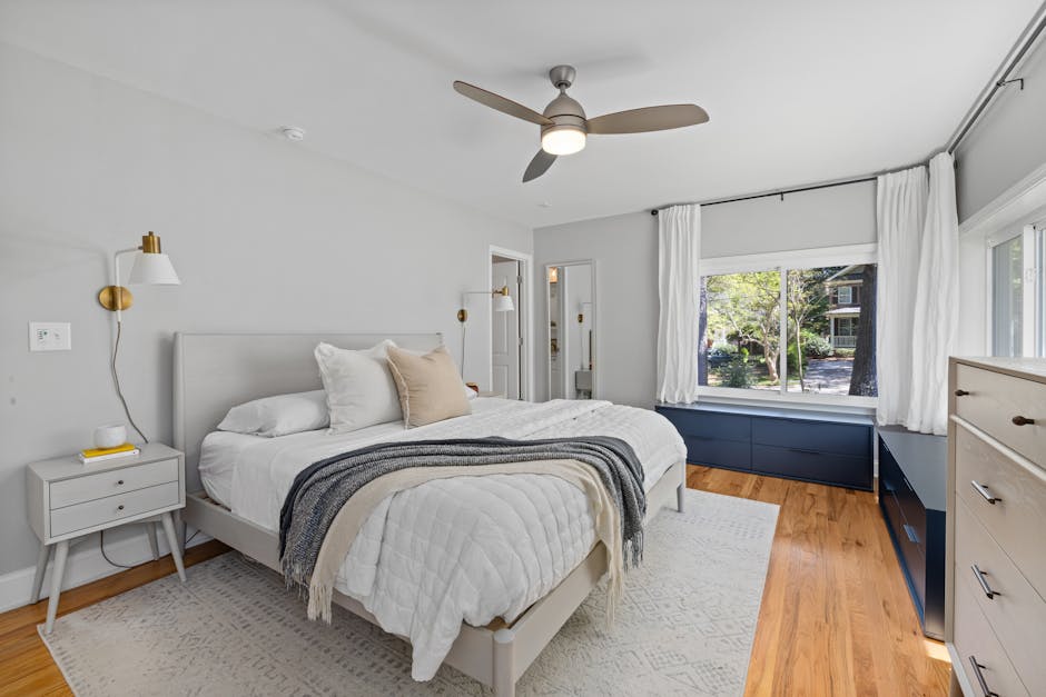 Chambre moderne et chaleureuse avec un design minimaliste, de grandes fenêtres et un sol en bois.