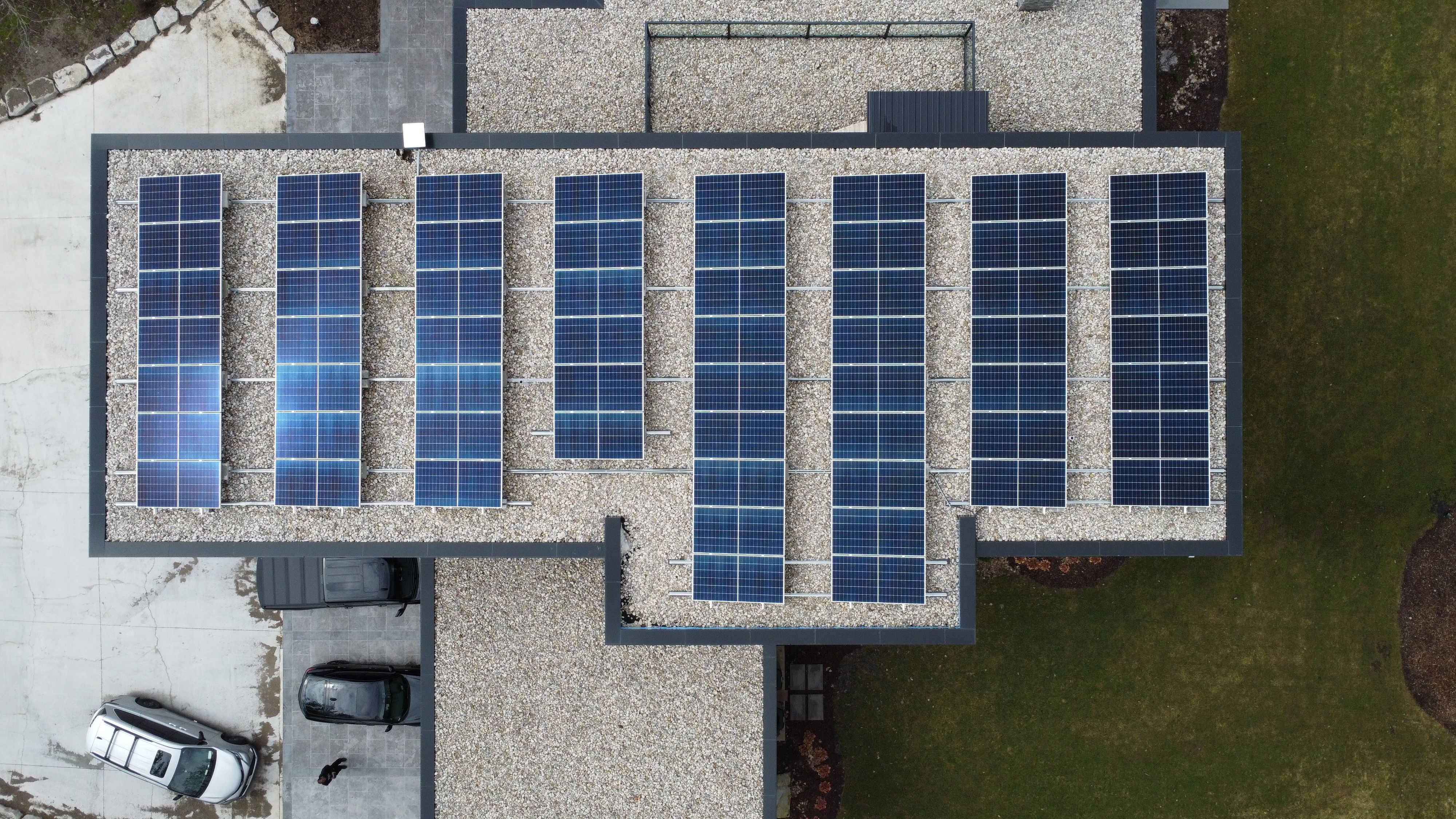 Aerial view of a flat-roof commercial building in Toronto with multiple solar panels installed, highlighting a solar installation on a flat roof.