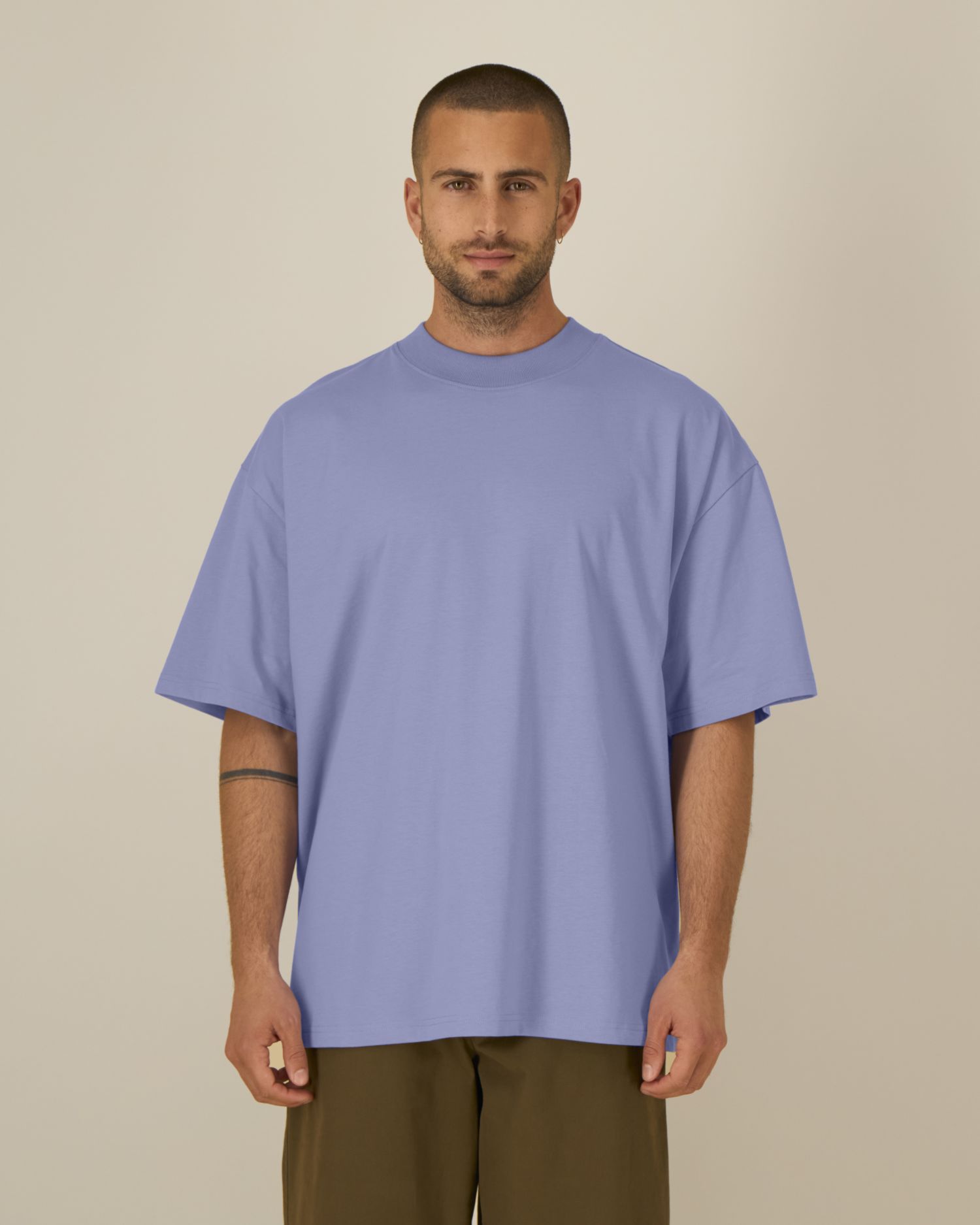 Homme debout portant un t-shirt surdimensionné bleu lavande, manches courtes, pantalon kaki, fond neutre. vous cherchez des vêtements de travail imprimés ? retrouvez-les sur mon vêtement de travail