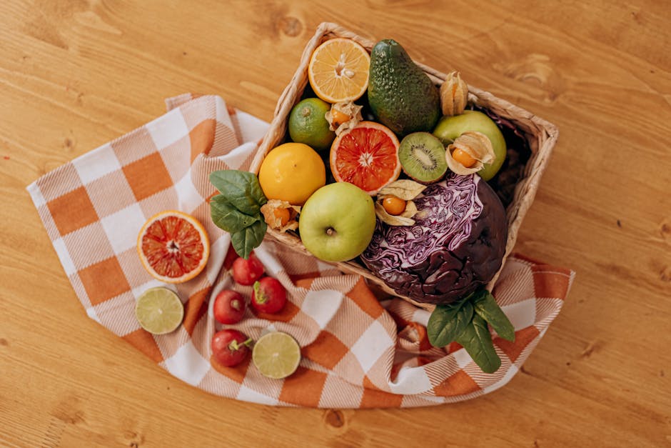 Un mélange coloré de fruits et légumes disposés dans un panier sur une table en bois rustique.