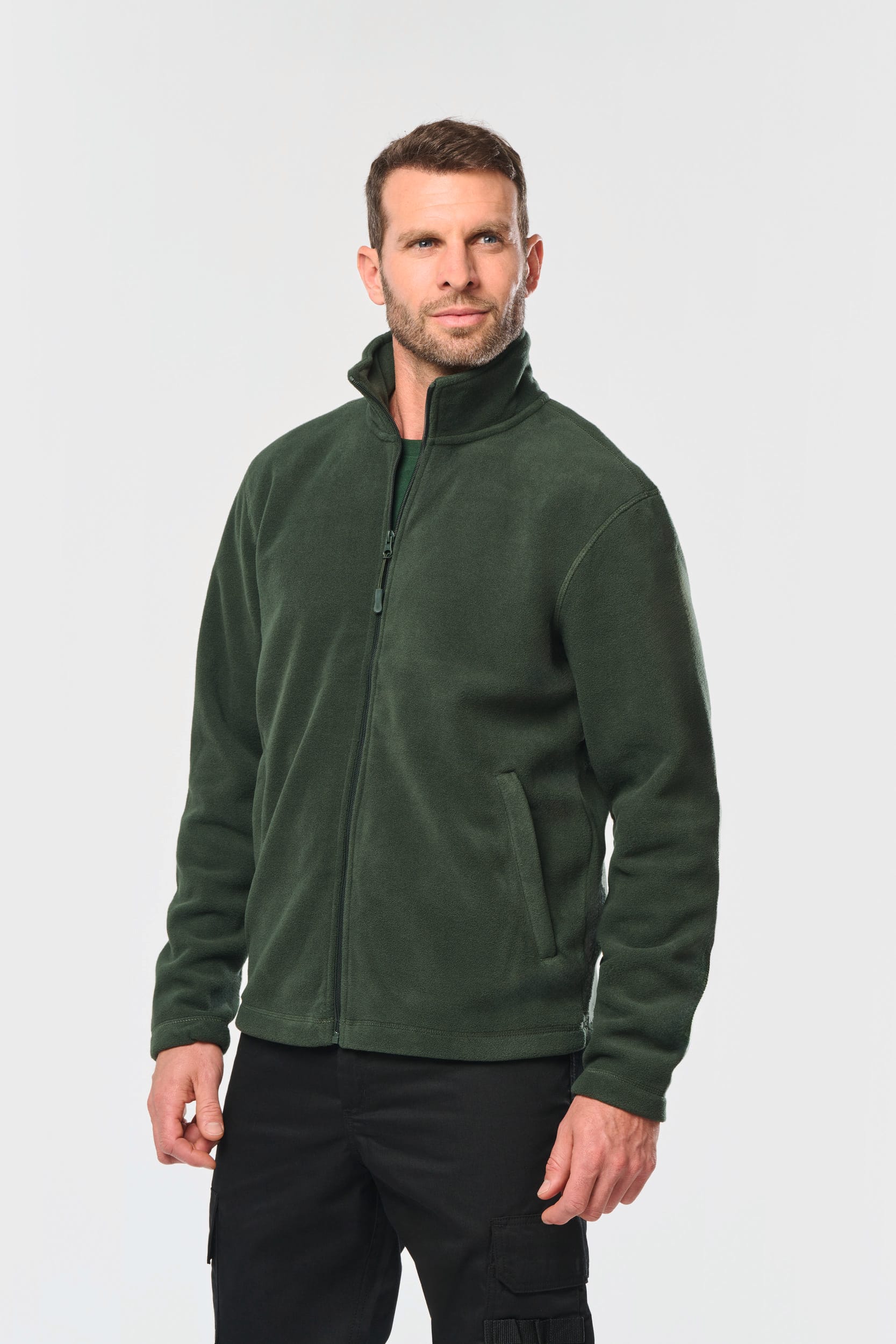 Vêtement de travail professionnel avec logo entreprise : homme portant veste polaire verte zippée, pose sérieuse.