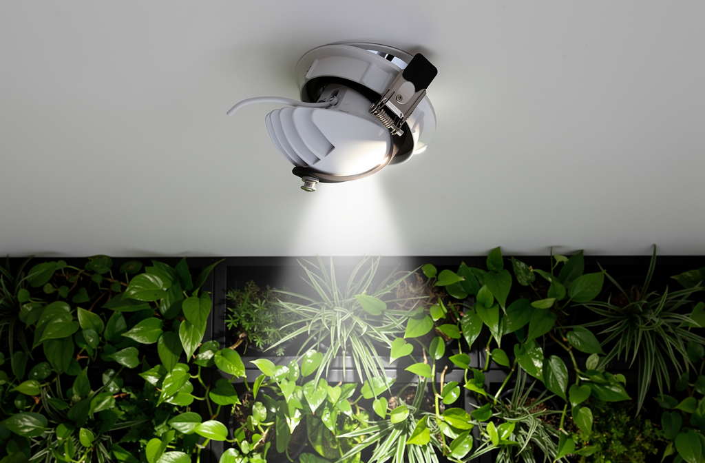 Spot LED horticole encastré au plafond éclairant un mur végétal intérieur luxuriant.