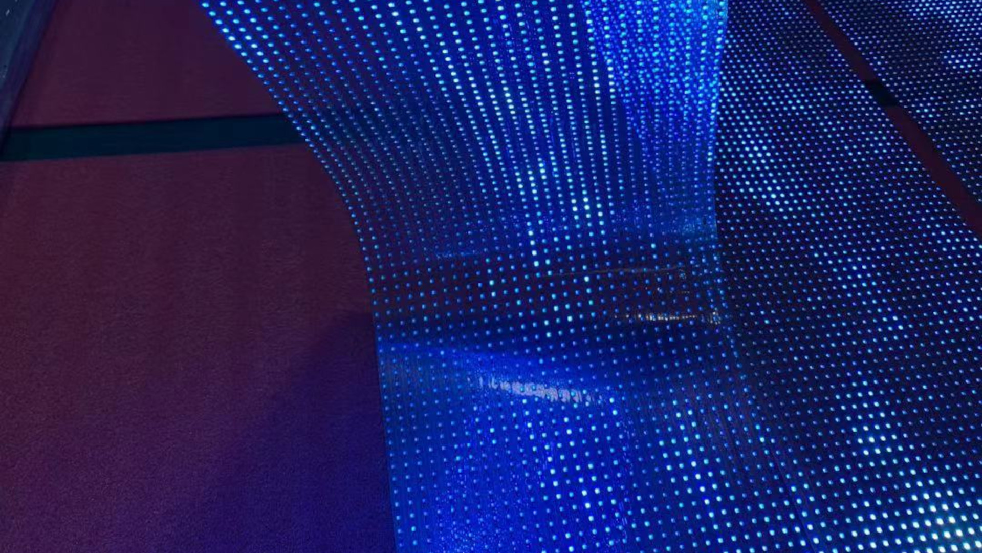 Texture numérique bleutée avec motifs en points, évoquant la luminosité idéale d'un écran dans un décor sombre.