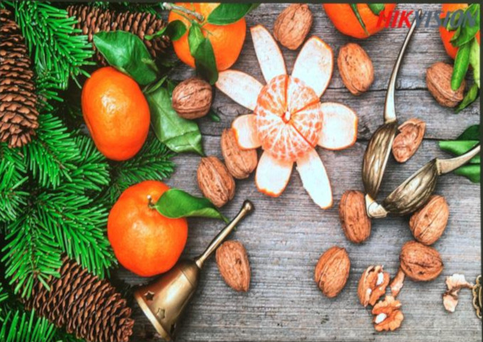 Écran LED atypique agence communication: fruits et noix décoratifs sur bois, logo discret en coin.