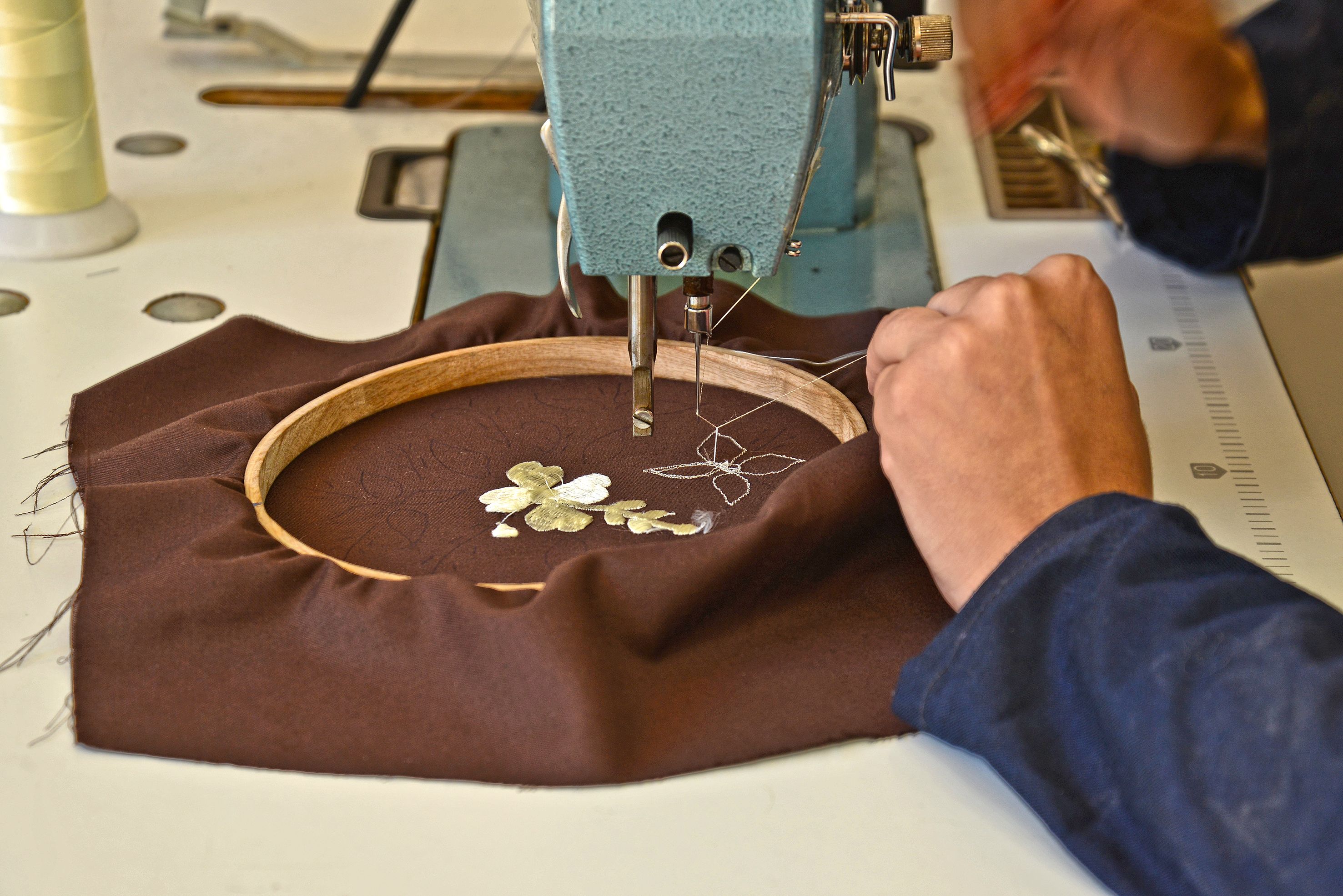 Machine à broder en cours de travail sur un tissu tendu dans un cercle de broderie