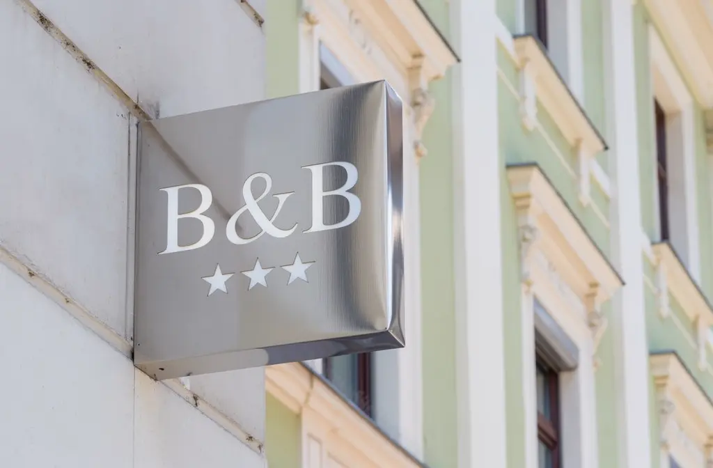 Insegna di un bed and breakfast a tre stelle montata sulla facciata di un edificio.