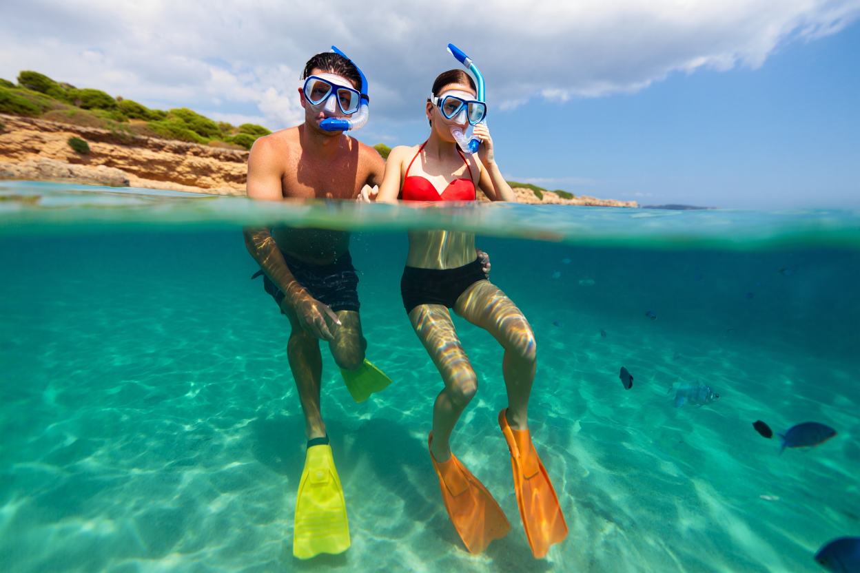 Due persone che praticano snorkeling insieme mantenendo contatto visivo