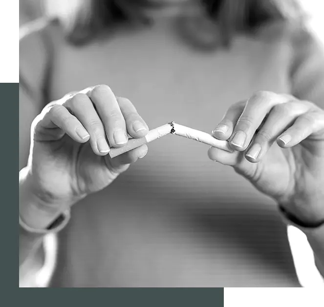 Une personne casse en deux un paquet de cigarettes