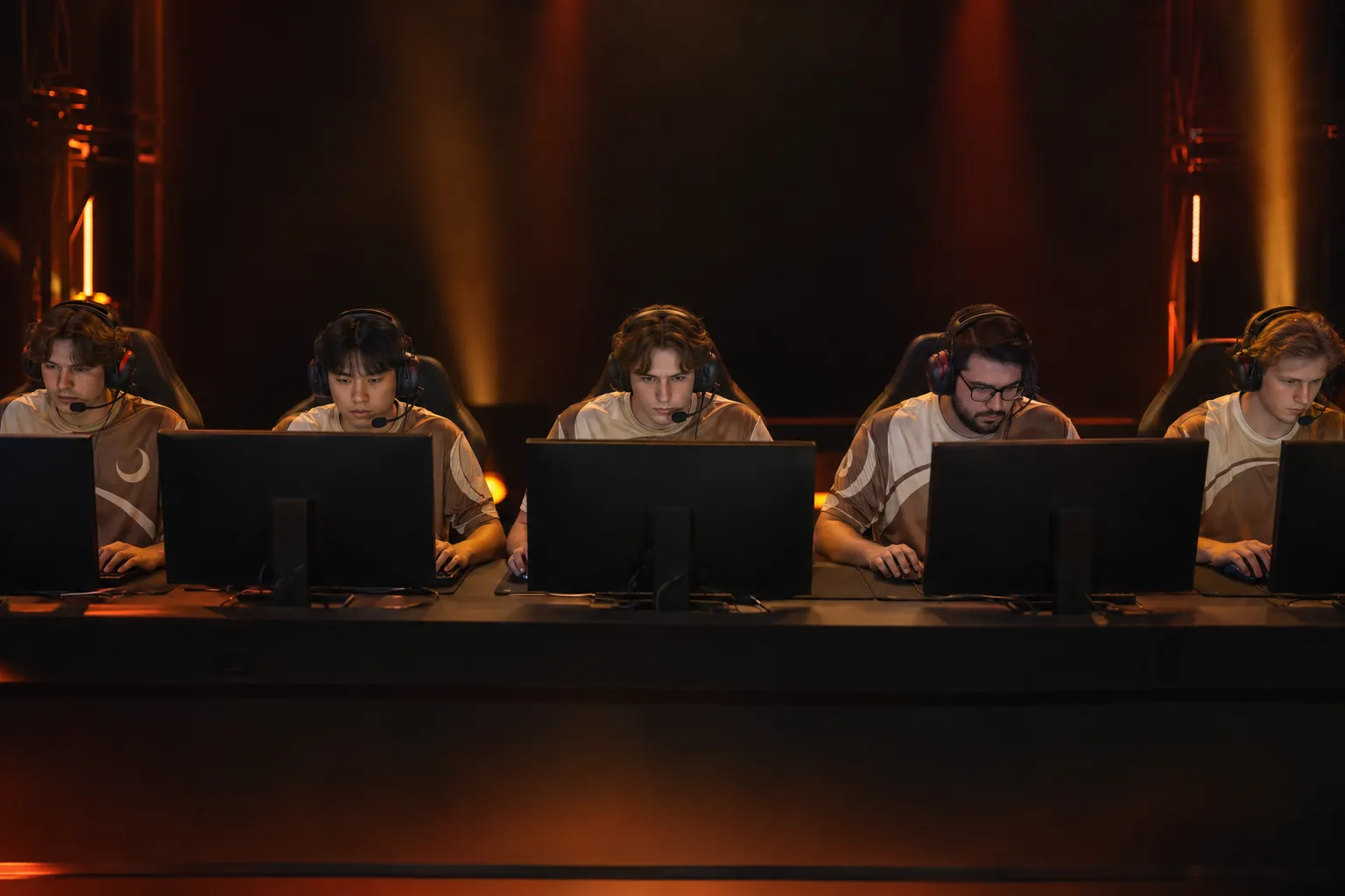 Équipe esport de cinq joueurs en compétition sur scène, vêtus de maillots esport personnalisés identiques