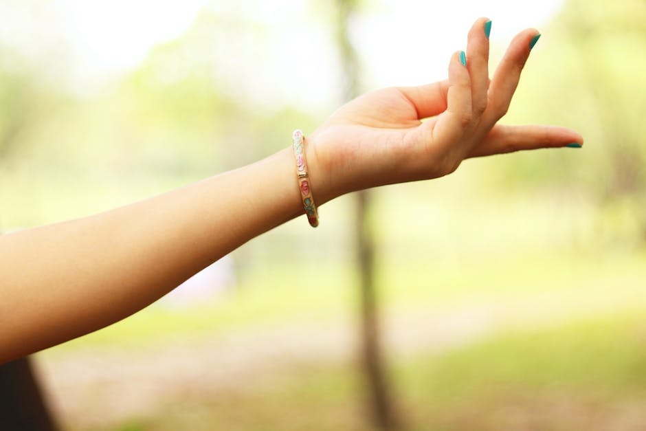 Gros plan de la main d'une femme portant un bracelet en extérieur, mettant en avant élégance et simplicité.